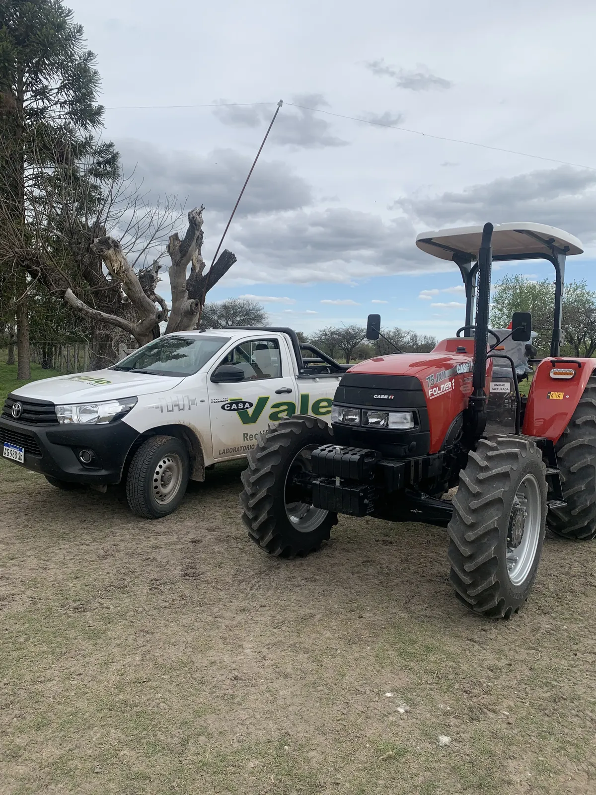 La camioneta de Casa Vale estacionada junto a un tractor Case IH 75 JXM en el campo de un cliente